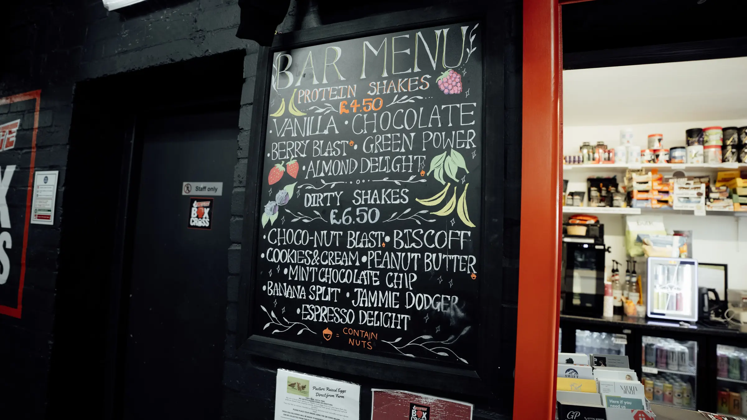 The hand-lettered bar menu at the BoxCross nutrition bar, listing protein shakes and dirty shakes