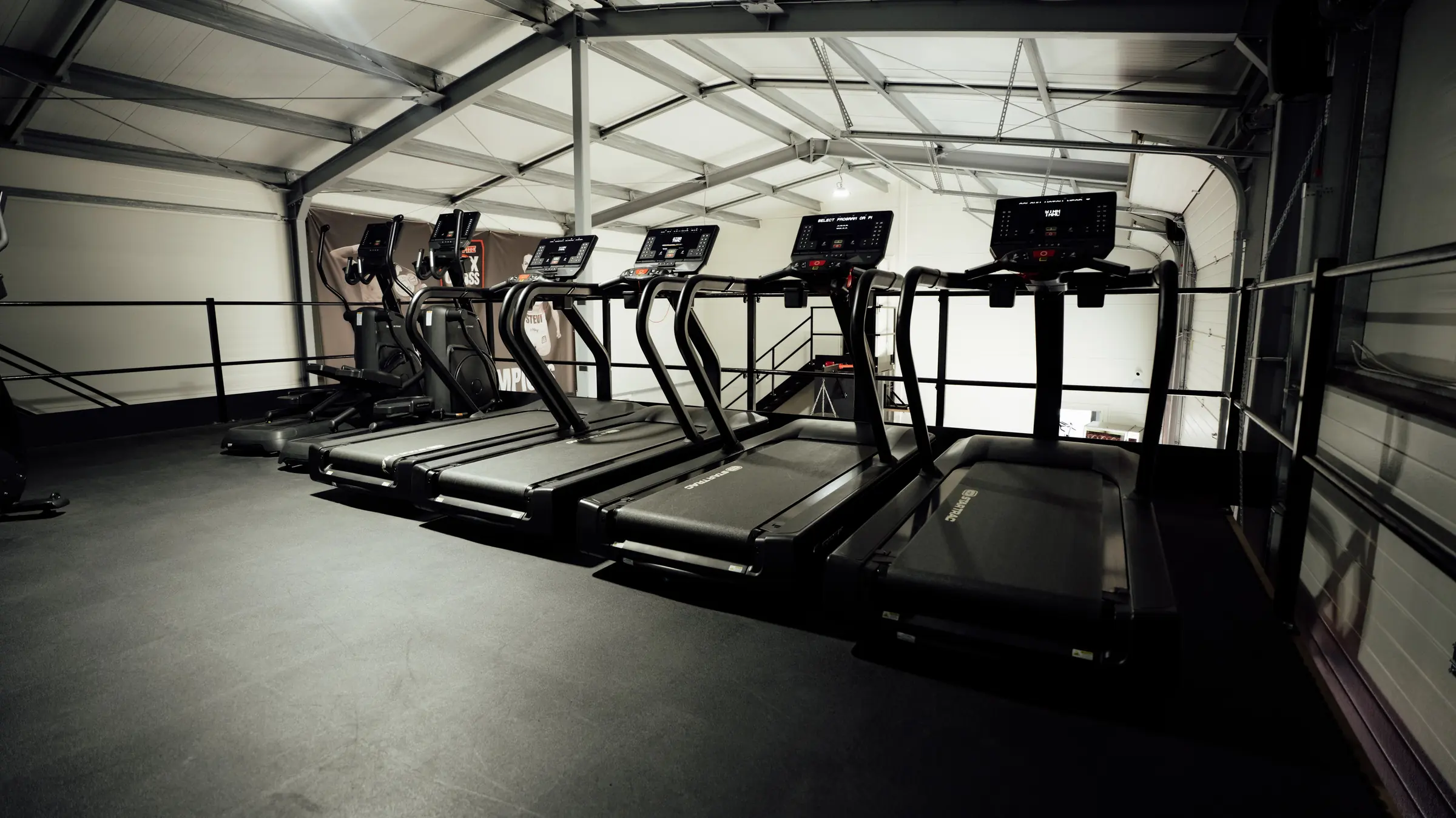 Treadmills and cross trainers on the mezzanine cardio deck above the boxing rings