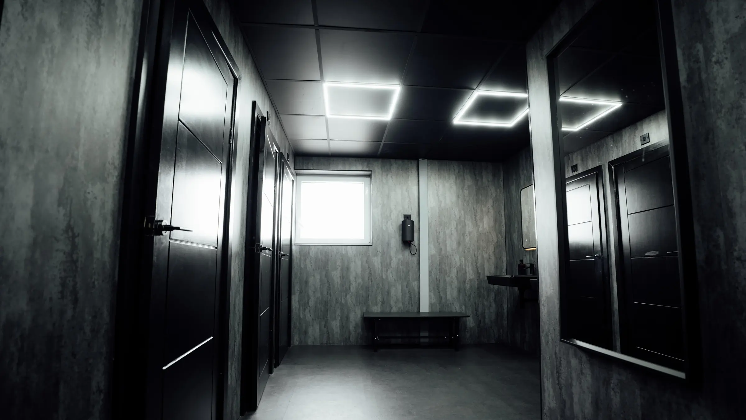 The corridor between cubicles with the window at the end