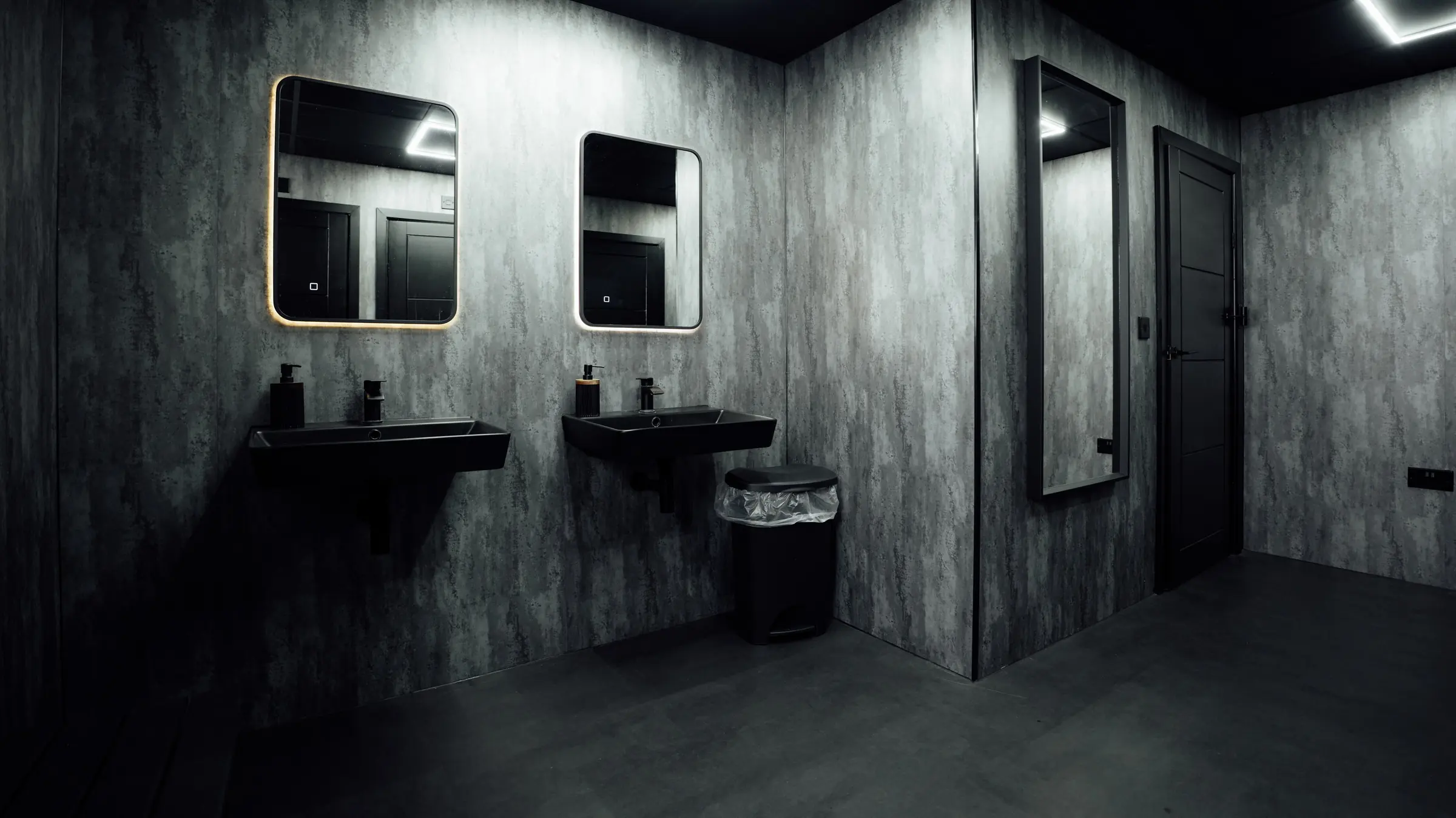 Black basins and backlit mirrors in the new gents changing room