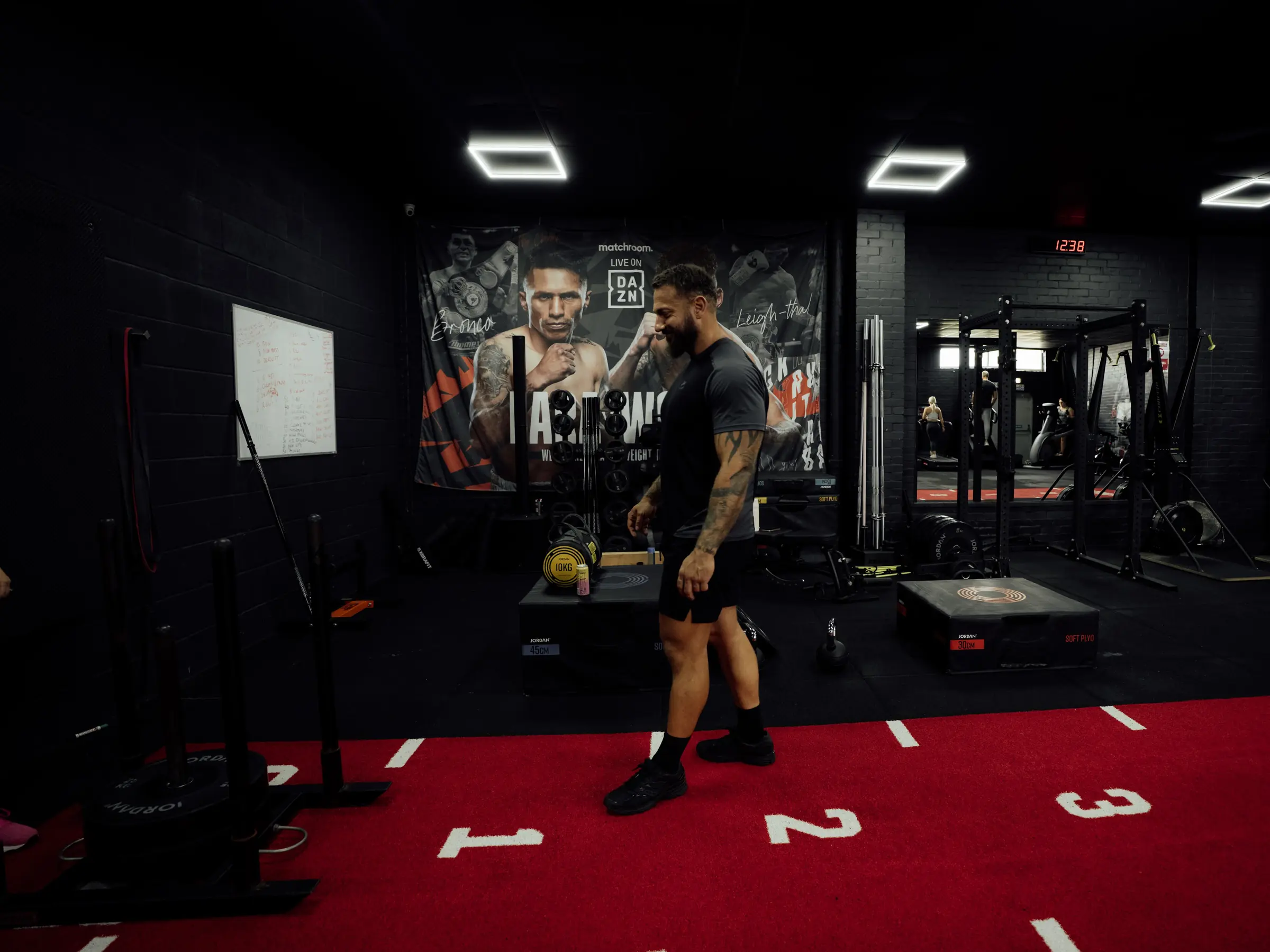 A coach setting up a loaded sled on the red track in the functional area