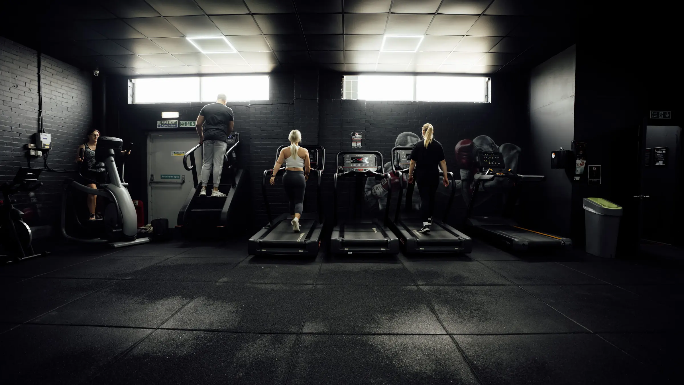 Members running on the treadmills by the window