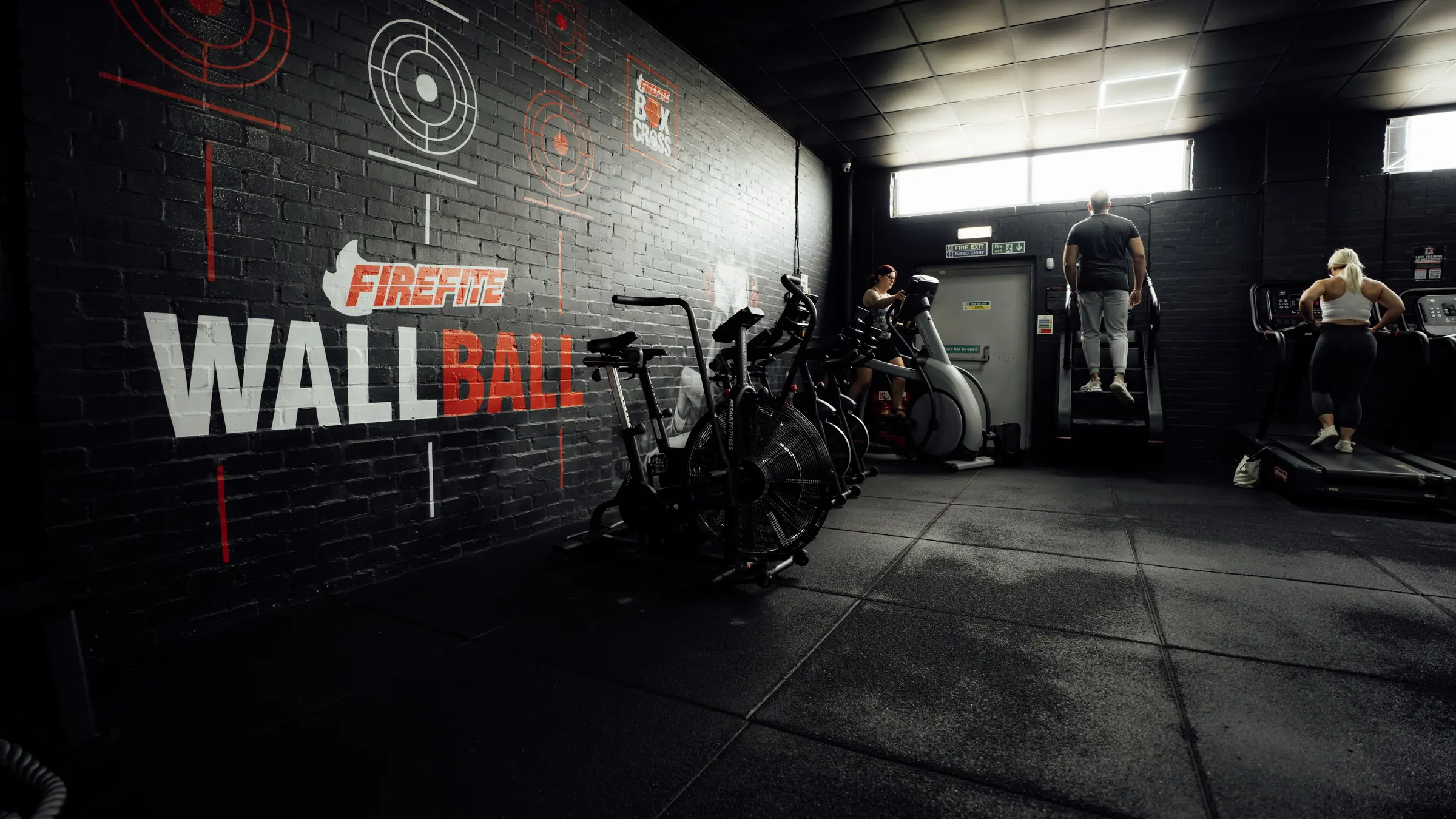 The wall ball wall and air bikes in the functional room where boxfit runs at BoxCross UK