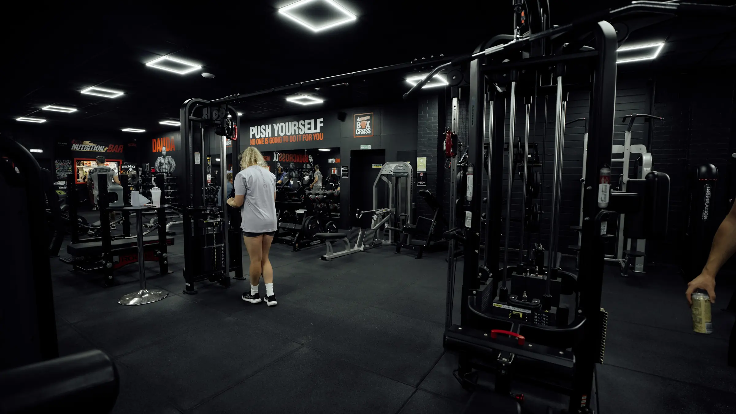 A woman training on the cable station on the main floor at BoxCross UK Wisbech
