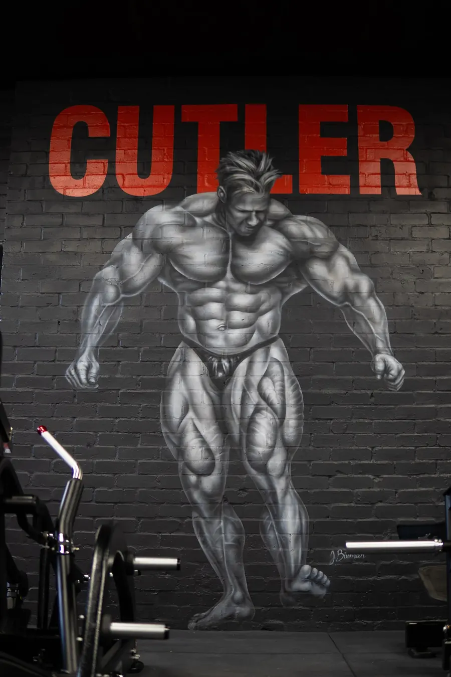 Hand-painted bodybuilder mural on black brick inside BoxCross UK Wisbech