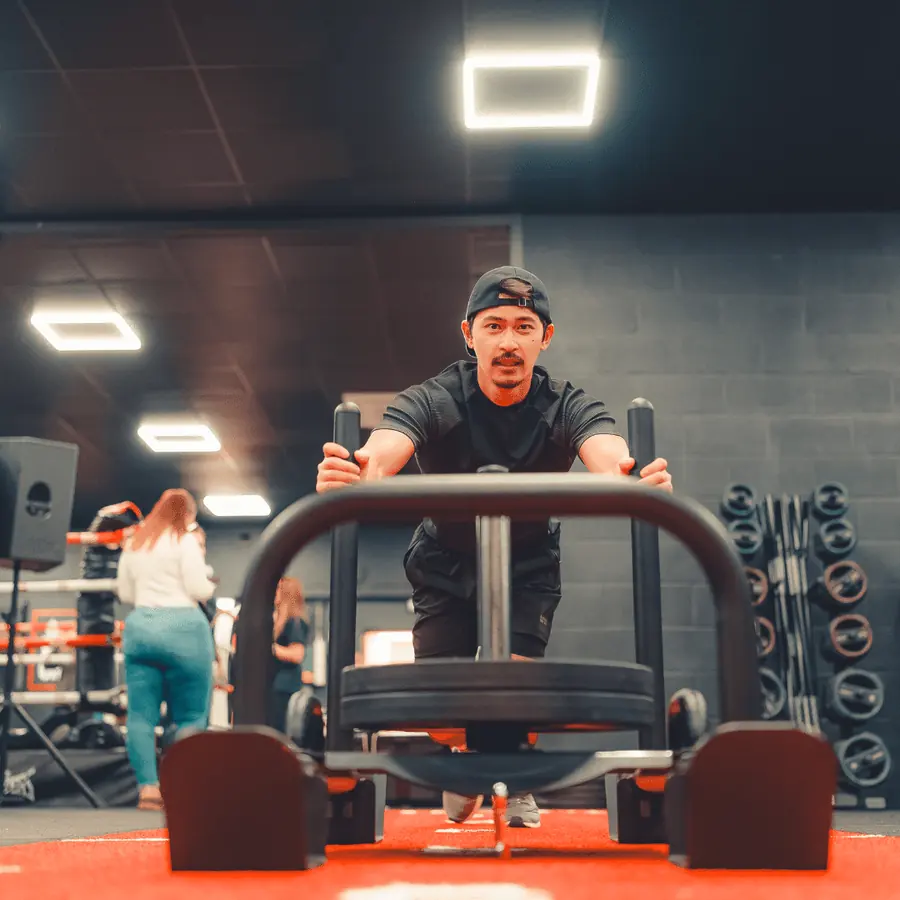 A member driving a loaded sled down the red track during a functional class