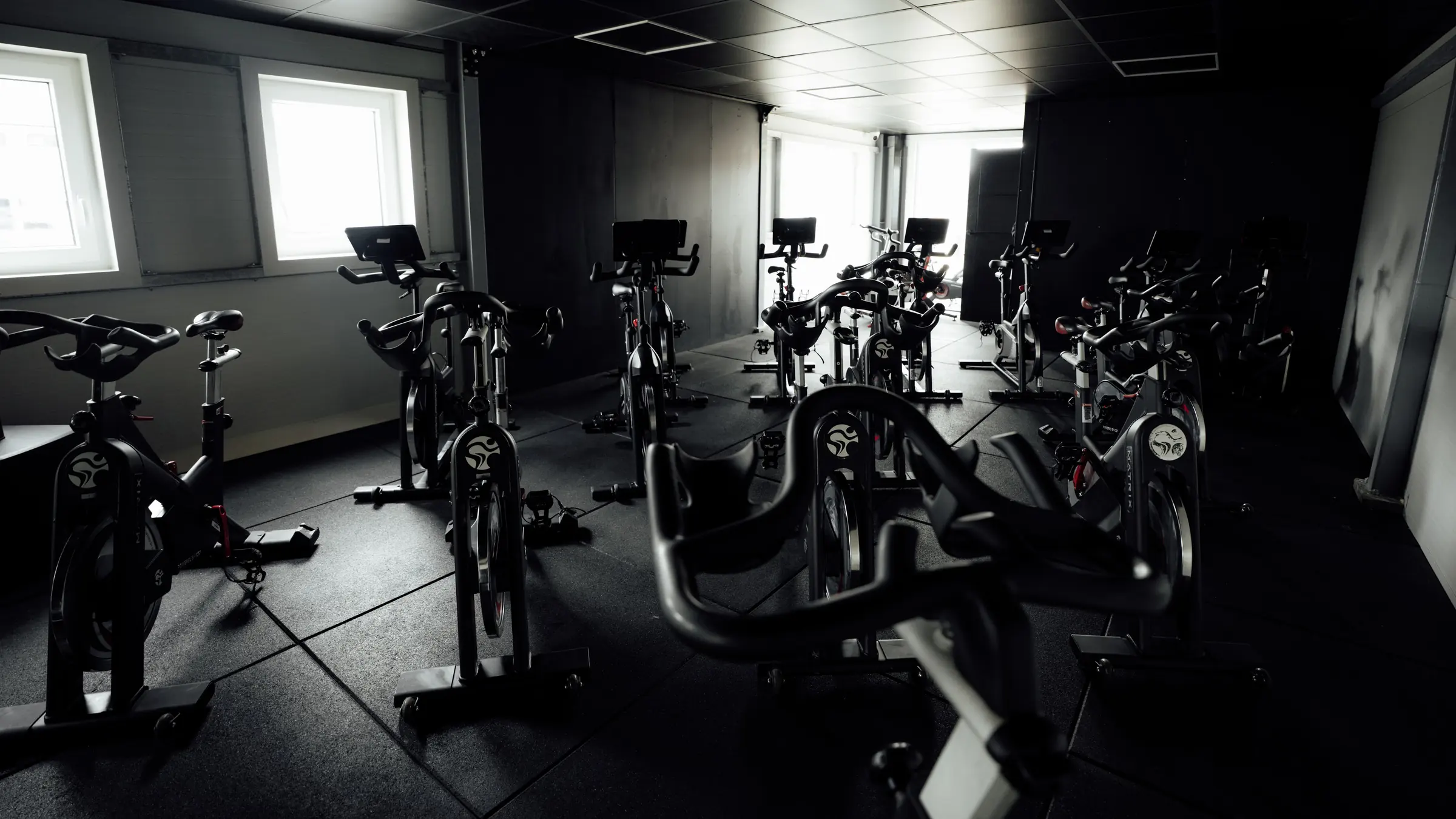 Rows of spin bikes in the BoxCross Ride studio, lit by the windows
