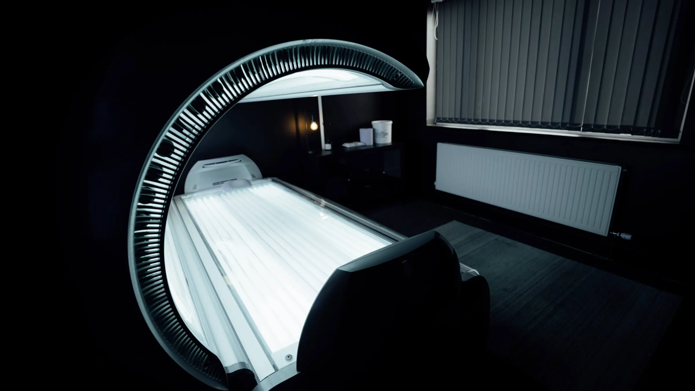 A Luxura lay-down sunbed open and lit beside the window in the BoxCross tanning studio in Wisbech