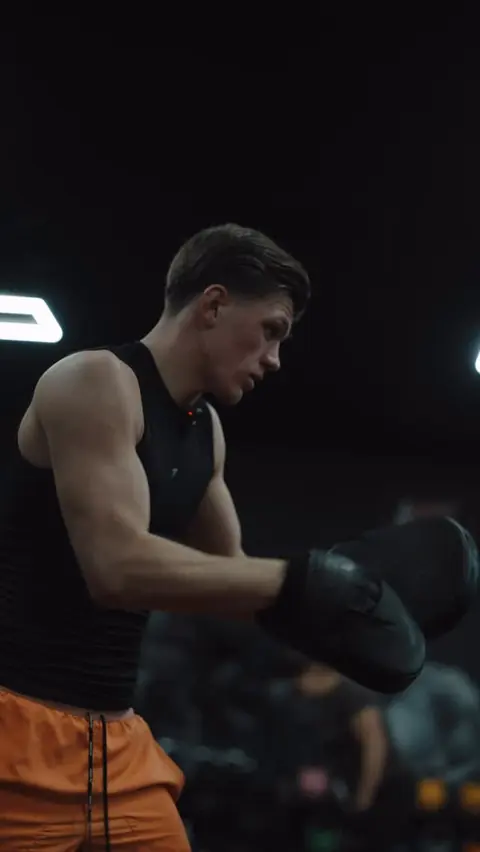 A professional boxer coaching a youth boxing class